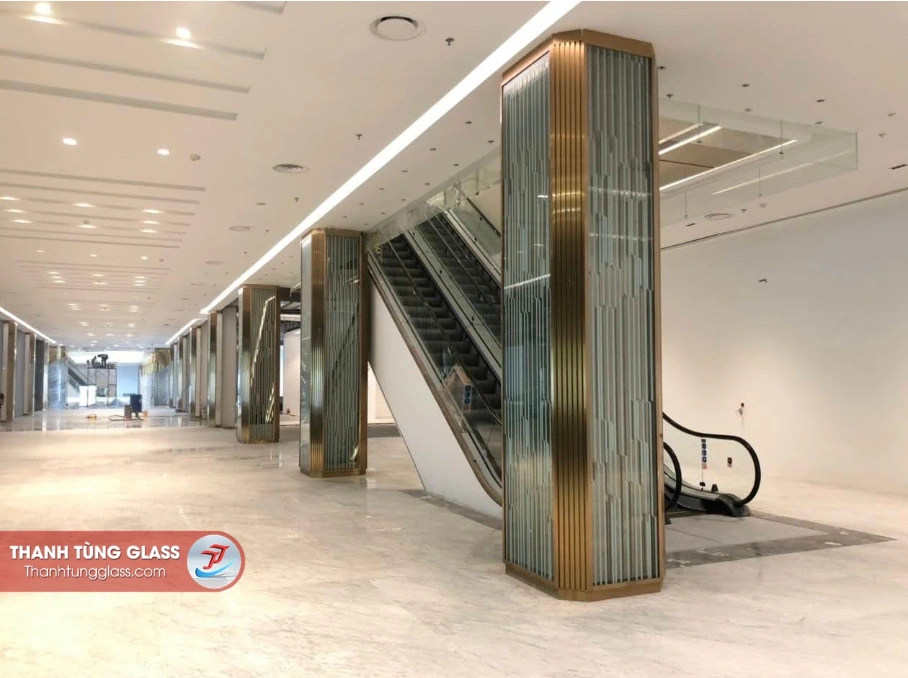 Cận cảnh kính vân nghệ thuật ốp cột và lan can kính khu thang cuốn