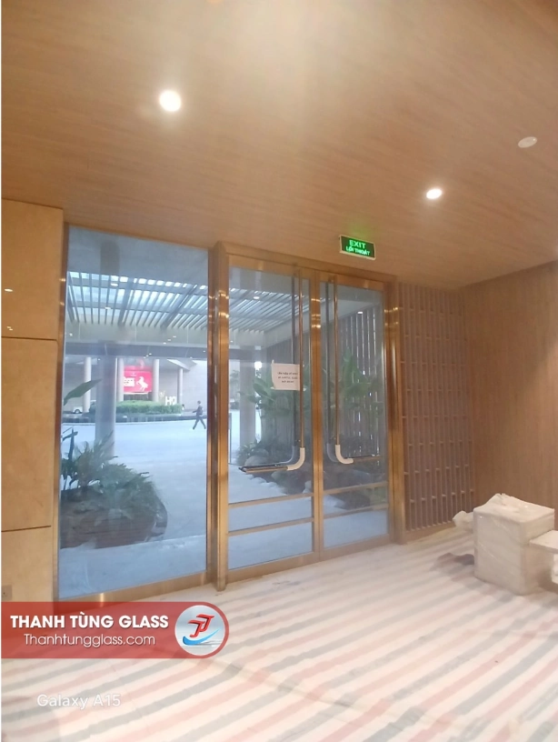 Cửa kính cường lực hai cánh khung nhôm Slim vàng champagne tại khu vực thoát hiểm Resort Hoiana